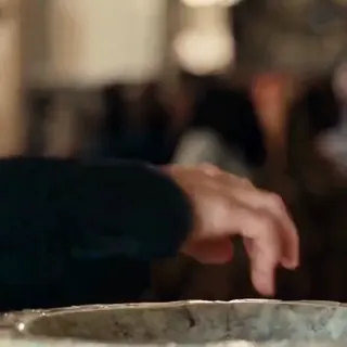 0:03–0:04 — A hand dips into the water in a stone basin.